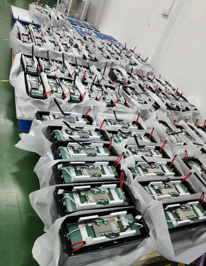 Open battery packs with BMS boards and red and black power cables visible