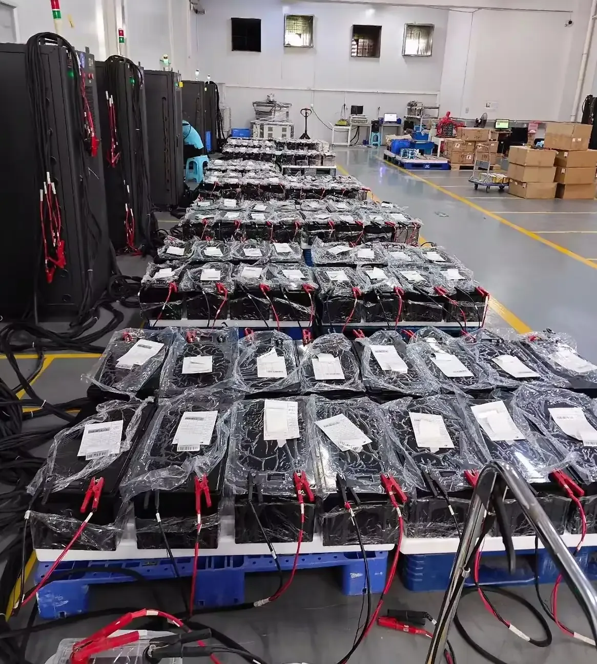 TUORDE Battery Pack Workshop Testing Photograph TUORDE battery packs connected to workshop testing equipment with red and black test leads during battery production evaluation