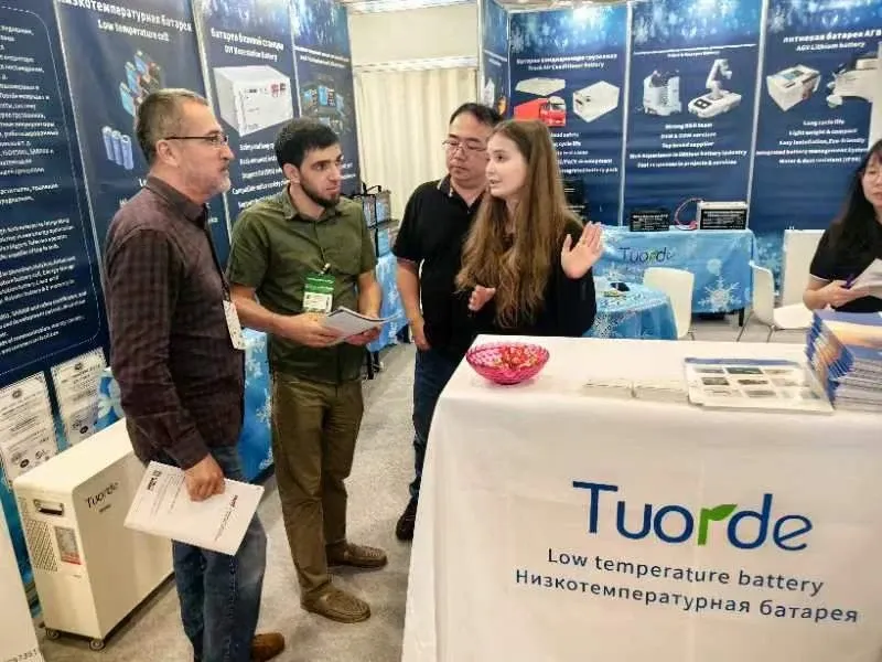 TUORDE team discussing battery products with exhibition visitors in Tajikistan